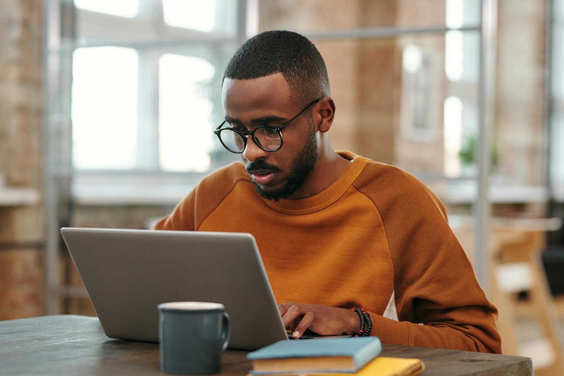 a man learns ruby on rails in a sweater using a laptop