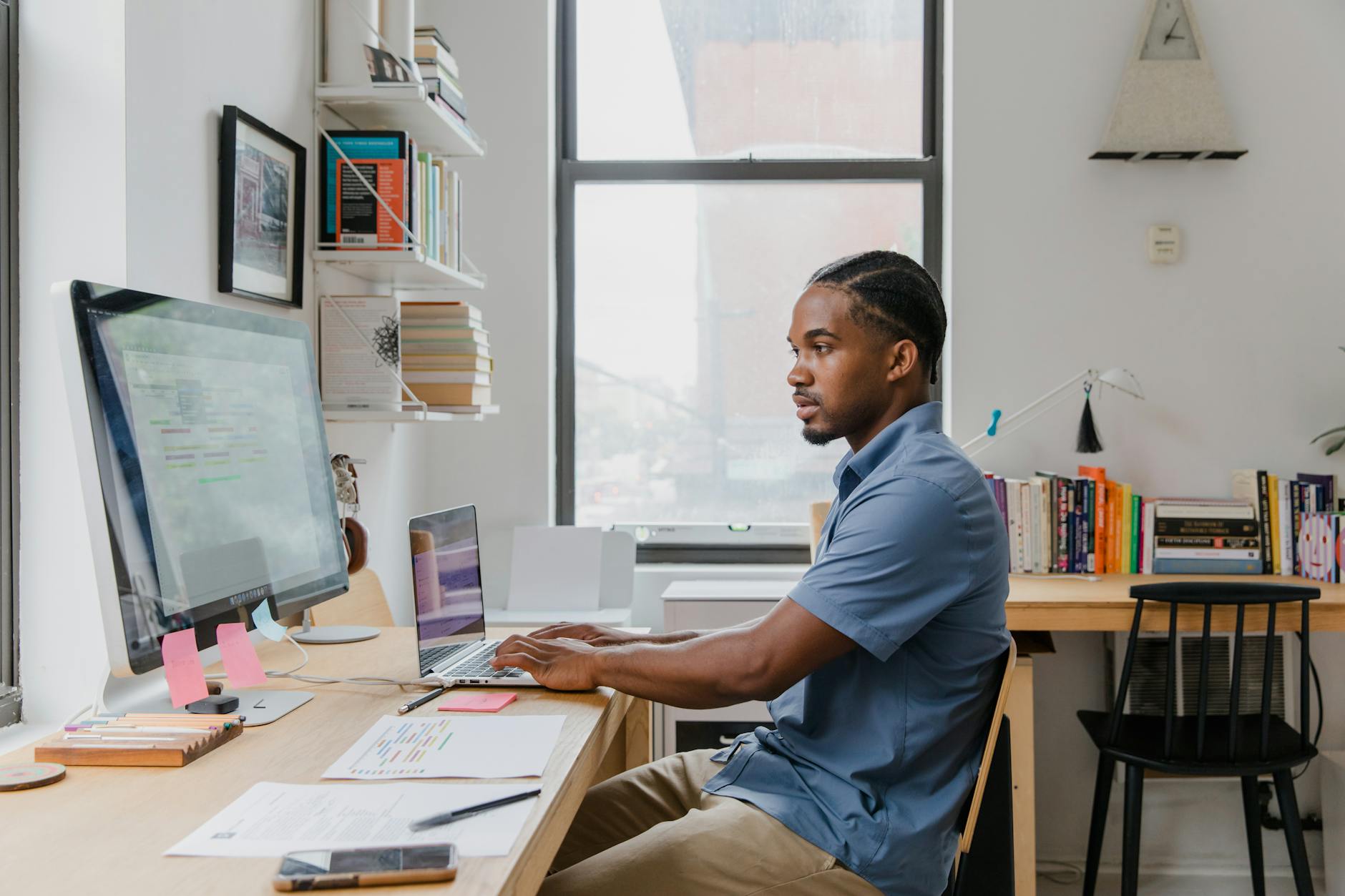 man working at desk with computers in office