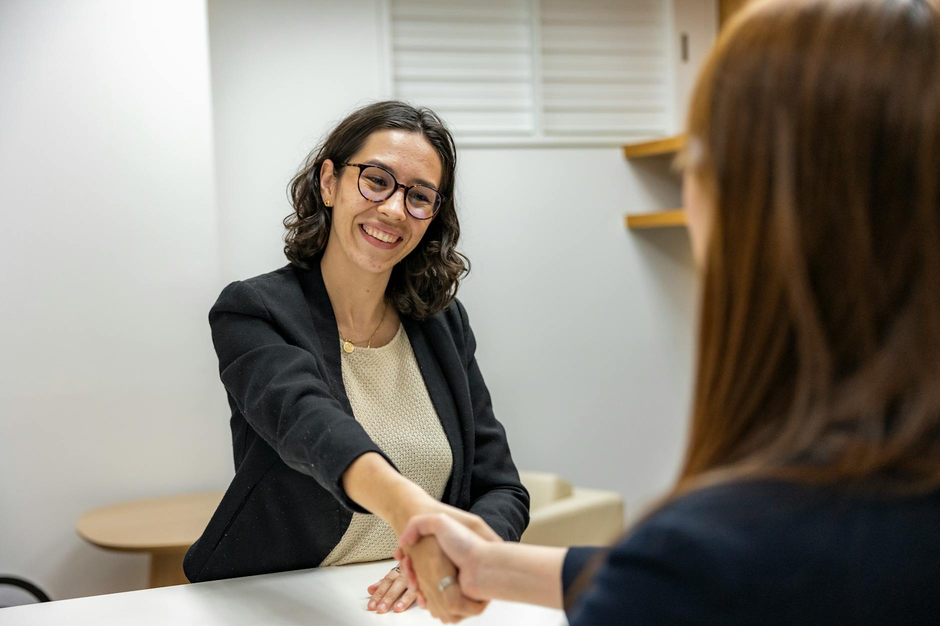 Acquisition Instead of Recruiting. young woman in business attire shaking hands with recruiting manager after job interview